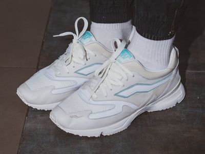 A pair of modern running shoes on a dark floor.